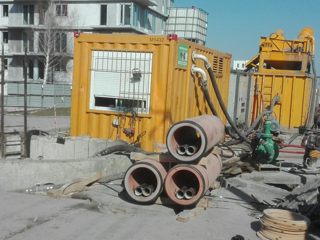 Agregaty i betonowe rury przygotowane do przecisku pod ulicą.