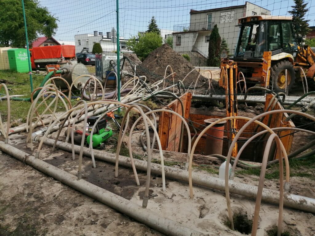 Zbrojenie i rury przygotowane na placu budowy przepompowni ścieków.